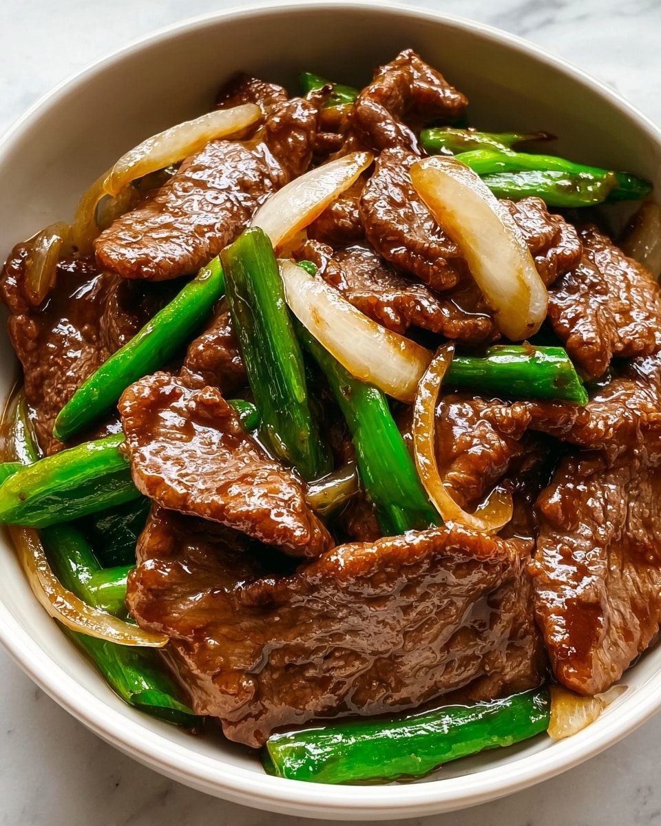 The image shows a close-up of a white bowl filled with glossy stir-fried beef slices that are brown with a slightly wrinkled texture, mixed with bright green, crisp-looking scallion pieces and translucent, pale yellow onion slices. The beef and vegetables are coated in a shiny, thick brown sauce that reflects light, making the dish look moist and flavorful. The bowl is set on a white marbled surface. photo taken with an iphone --ar 4:5 --v 7